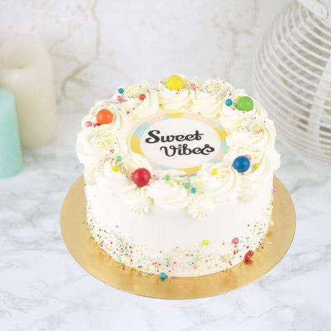 Foto / Logo Taart met de logo van Sweet Vibes erop en gedecoreerd met gekleurde sprinkles