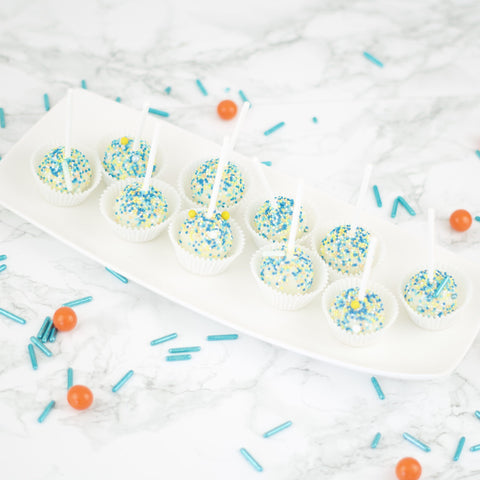Witte cakepops met blauwe, oranje en gele sprinkles